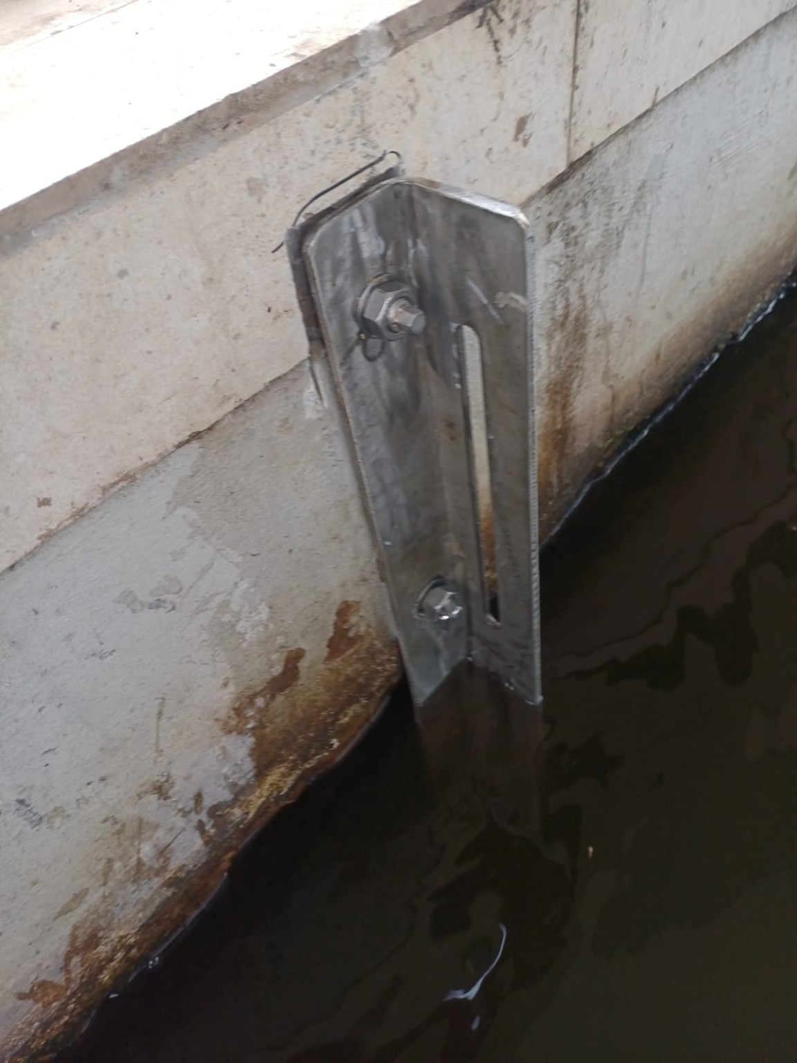 Close-up of stainless steel angle reinforcement and chemical anchor installation